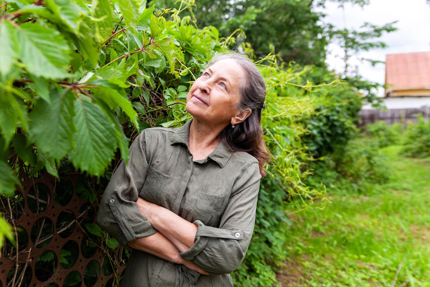 Image of a mature woman deep in thought in her garden