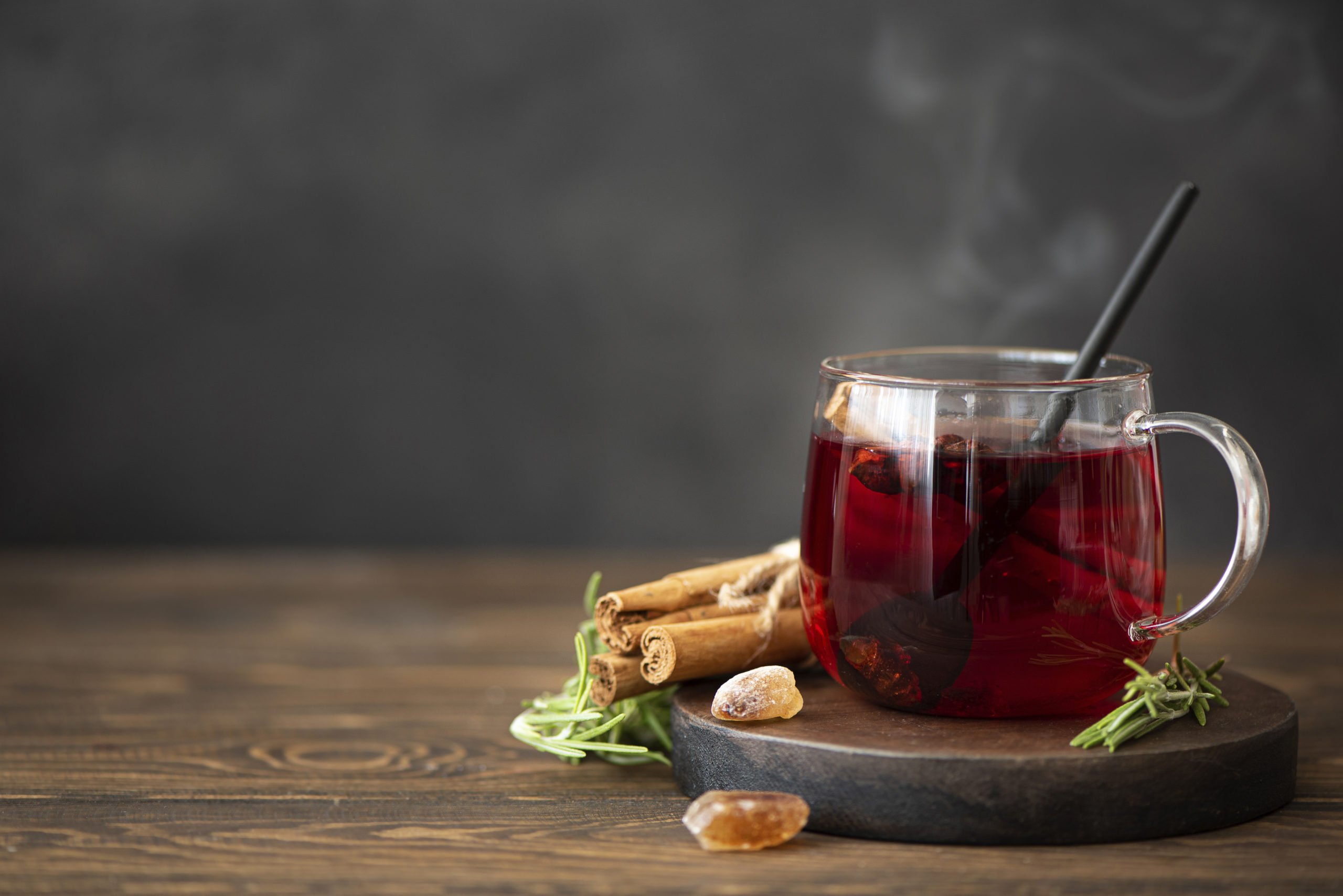 Image of hot hibiscus tea with cinnamon and sugar on a wooden table