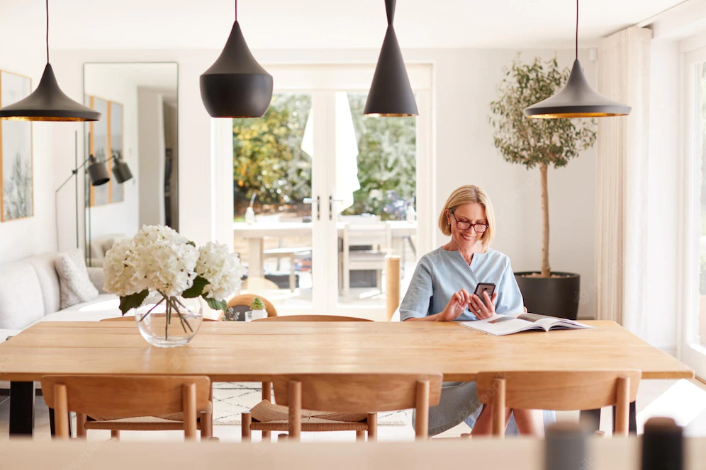 Image of a senior woman relaxing at home with her mobile phone